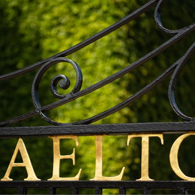 Photo of the gold lettering AELTC from the gate at Wimbledon.