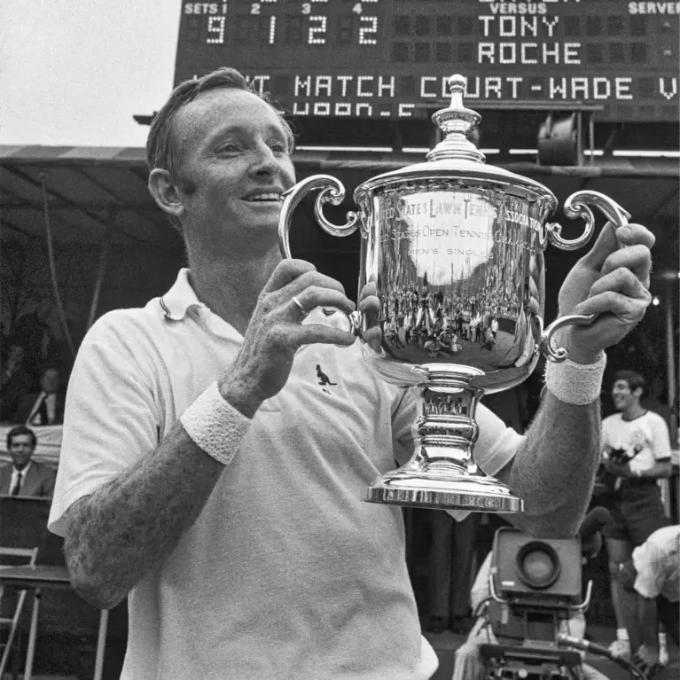 Black and white image of male tennis player holding trophy