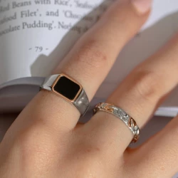 Clogau Tree of Life Ring on models finger against the pages of a book
