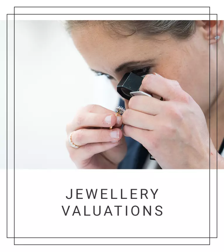 Blonde woman looking at a ring using a jewellers loupe