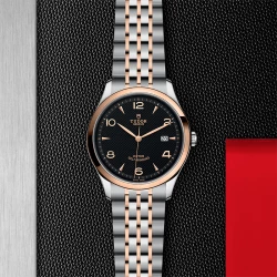 Tudor 1926 41mm Watch with embossed black dial and rose gold detail against branded backboard